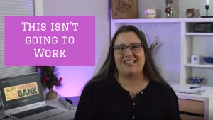 Image of a middle aged woman with brown hair in a black shirt sitting at a desk. The words "This isn't going to work" are written on the screen in white letters on a pink background.